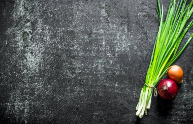 Farklı türde soğanlar. Koyu rustik arka plan üzerinde