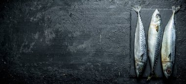 Taş tahtada balık uskumru. Siyah rustik arka plan üzerinde