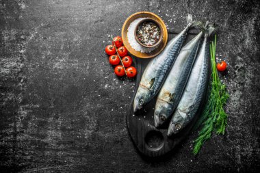 Dereotu, baharat ve domates ile kesme Tahtası üzerinde çiğ uskumru. Koyu rustik arka plan üzerinde