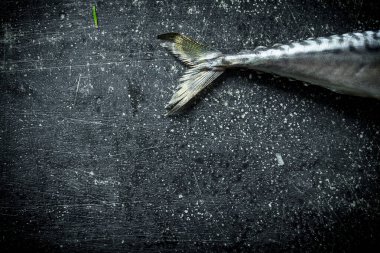 Çiğ uskumru kuyruğu. Koyu rustik arka plan üzerinde