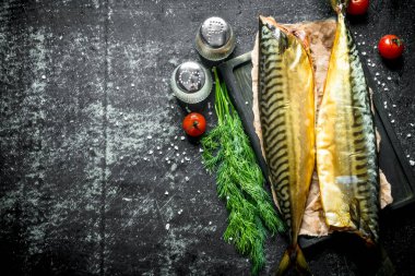 Baharat, dereotu ve kiraz domates ile füme uskumru. Koyu rustik arka plan üzerinde