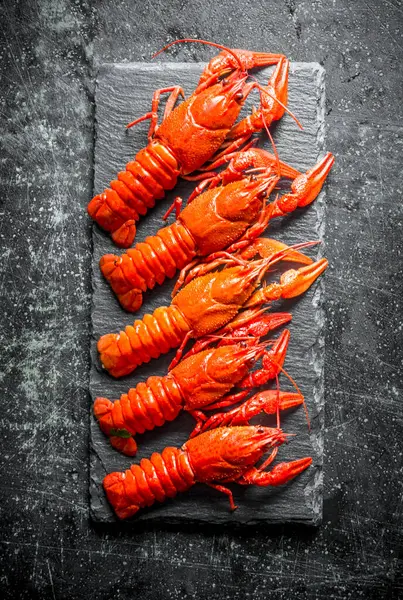 Taş tahtada pişmiş kerevit. Koyu rustik arka plan üzerinde