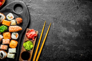 Somon, karides ve sebze ile suşi rulo farklı ayarlayın. Siyah rustik arka plan üzerinde