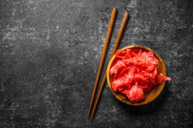 Zencefil yemek çubukları yla bir kapta. Koyu rustik arka plan üzerinde