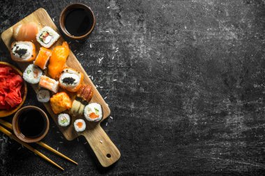 Taze suşi ve soya soslu rulolar. Koyu rustik arka plan üzerinde