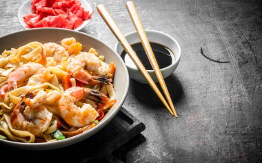 Kesme Tahtasıüzerinde karides ve sebze ile bir tabakta erişte. Koyu rustik arka plan üzerinde