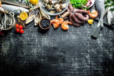 Otlar, domates ve limon ile deniz ürünleri. Koyu rustik arka plan üzerinde