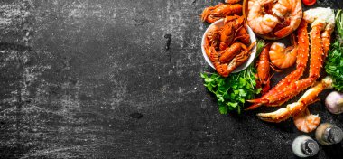 Pişmiş karides, kerevit ve maydanozlu yengeç. Koyu rustik arka plan üzerinde