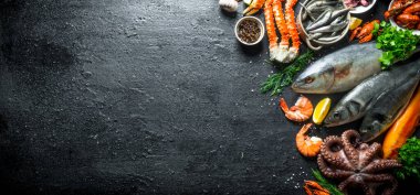 Taze balık ve deniz ürünleri. Siyah rustik arka plan üzerinde