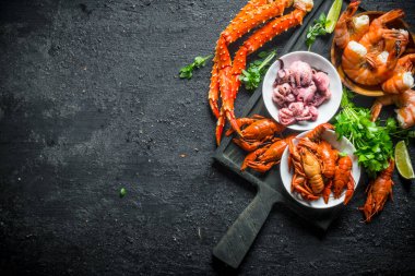 Kesme Tahtası'nda taze sağlıklı deniz ürünleri. Siyah rustik arka plan üzerinde