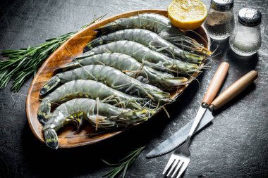 Biberiyeli taze çiğ karides. Koyu rustik arka plan üzerinde