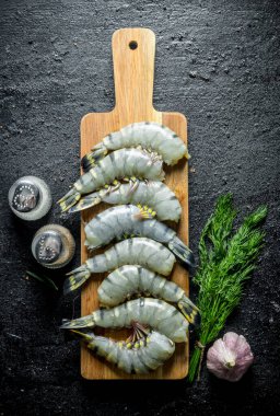 Dereotu ve sarımsak ile çiğ kaplan karides. Siyah rustik arka plan üzerinde