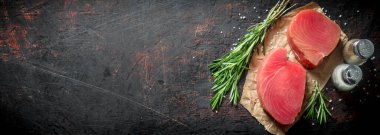 Biberiye ve baharatile taze çiğ ton balığı parçaları. Koyu rustik arka plan üzerinde