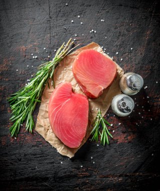 Biberiye ve baharatile taze çiğ ton balığı parçaları. Koyu rustik arka plan üzerinde