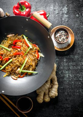 Zencefil, baharat ve sebze ile bir tavada Çin selofan erişte. Koyu rustik arka plan üzerinde