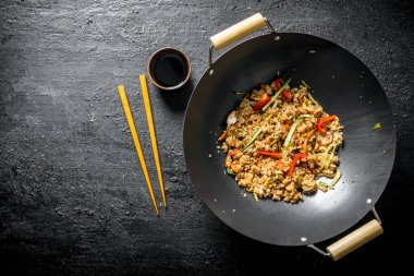 Tavuk ve sebze ile kokulu wok pirinç. Koyu rustik arka plan üzerinde