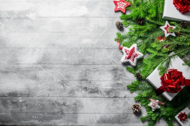 İçinde Noel süslemeleri, koniler ve köknar dalları olan hediye kutuları. Beyaz kırsal arkaplanda