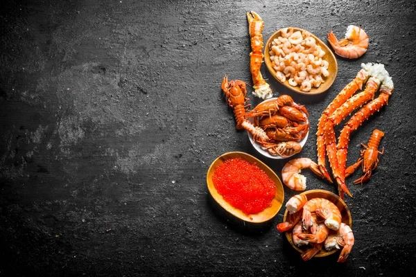 带煮小龙虾 螃蟹和鱼子酱的盘子 在黑色质朴的背景 — 图库照片