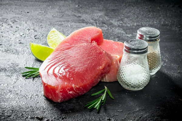 Filet Tuńczyka Surowego Przyprawami Rozmarynem Limonką Czarnym Tle Rustykalnym — Zdjęcie stockowe