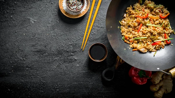 stock image Wok rice with spices, soy sauce and bell pepper. On black rustic background