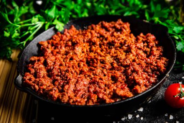 Kızartma tavasında bolonez sosu, makarnalı ve maydanozlu. Siyah bir arka planda. Yüksek kalite fotoğraf