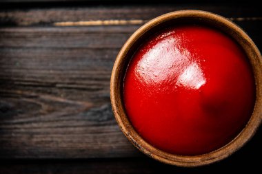 Masadaki bir kasede domates sosu. Ahşap bir arka planda. Üst Manzara. Yüksek kalite fotoğraf