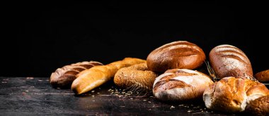 Taze ekmeğin farklı türleri. Siyah bir arka planda. Yüksek kalite fotoğraf