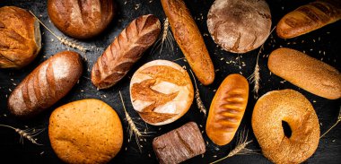 Masada farklı taze ekmek türleri var. Siyah bir arka planda. Yüksek kalite fotoğraf