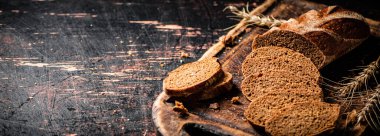 Tahta kesme tahtasında mis kokulu ekmek dilimleri. Karanlık bir arka plana karşı. Yüksek kalite fotoğraf