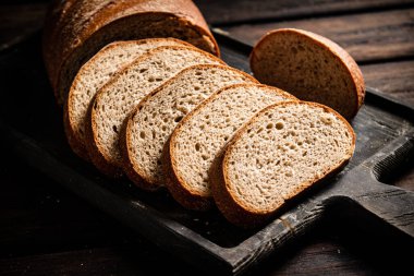 Kesme tahtasında dilimlenmiş ekmek. Ahşap bir arka planda. Yüksek kalite fotoğraf