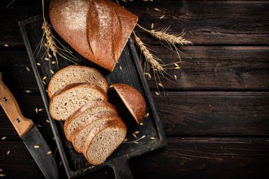 Kesme tahtasında dilimlenmiş ekmek. Ahşap bir arka planda. Yüksek kalite fotoğraf