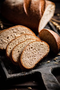 Kesme tahtasında dilimlenmiş ekmek. Ahşap bir arka planda. Yüksek kalite fotoğraf