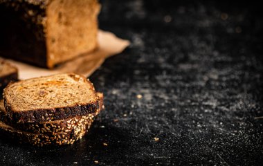 Kağıt üzerinde dilimlenmiş çavdar ekmeği. Siyah bir arka planda. Yüksek kalite fotoğraf
