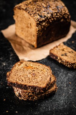 Kağıt üzerinde dilimlenmiş çavdar ekmeği. Siyah bir arka planda. Yüksek kalite fotoğraf