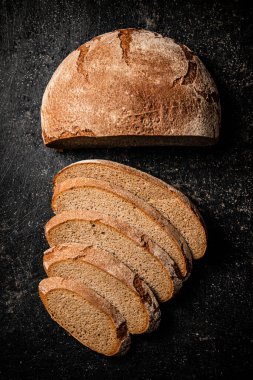 Masanın üzerinde taze çavdar ekmeği dilimleri. Siyah bir arka planda. Yüksek kalite fotoğraf