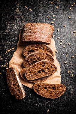 Kağıt üzerinde dilimlenmiş çavdar ekmeği. Siyah bir arka planda. Yüksek kalite fotoğraf