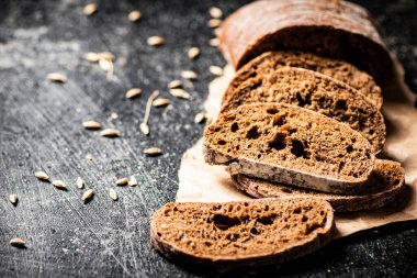 Kağıt üzerinde dilimlenmiş çavdar ekmeği. Siyah bir arka planda. Yüksek kalite fotoğraf