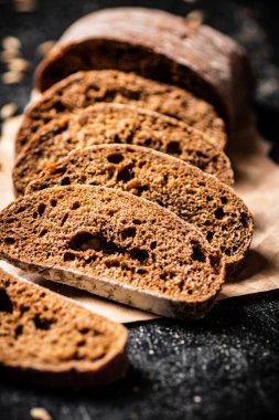 Kağıt üzerinde dilimlenmiş çavdar ekmeği. Siyah bir arka planda. Yüksek kalite fotoğraf
