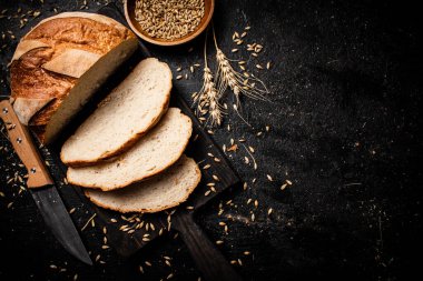 Kesme tahtasında dilimlenmiş buğday ekmeği. Siyah bir arka planda. Yüksek kalite fotoğraf