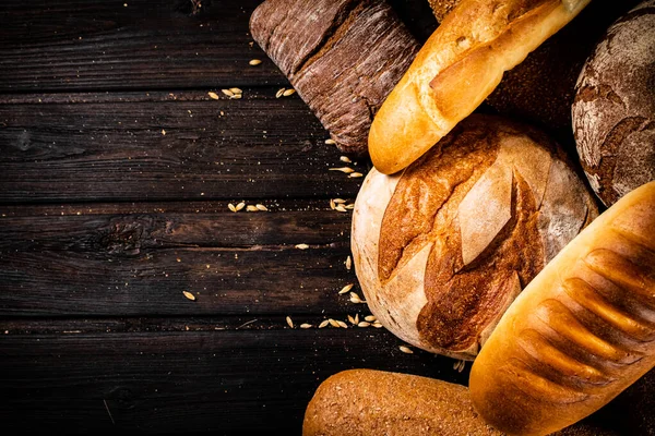 stock image Different types of freshly baked bread. On a wooden background. High quality photo