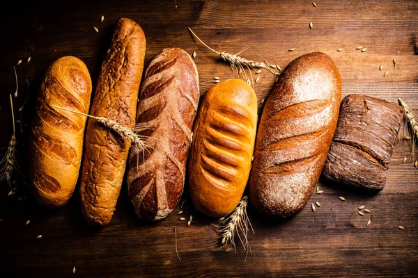 不同类型的新鲜烤面包 在木制的背景上 高质量的照片 — 图库照片