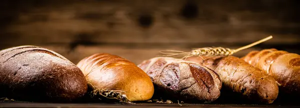 Verschillende Soorten Heerlijk Brood Een Houten Achtergrond Hoge Kwaliteit Foto — Stockfoto