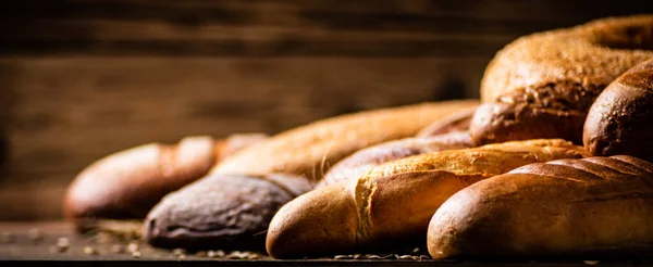 おいしいパンのさまざまな種類 木製の背景に 高品質の写真 — ストック写真