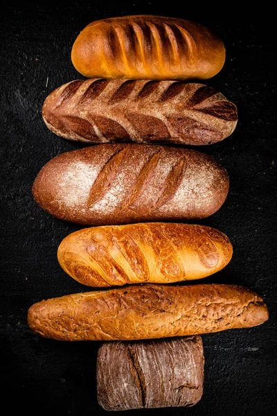 stock image A variety of fragrant fresh bread. On a black background. High quality photo