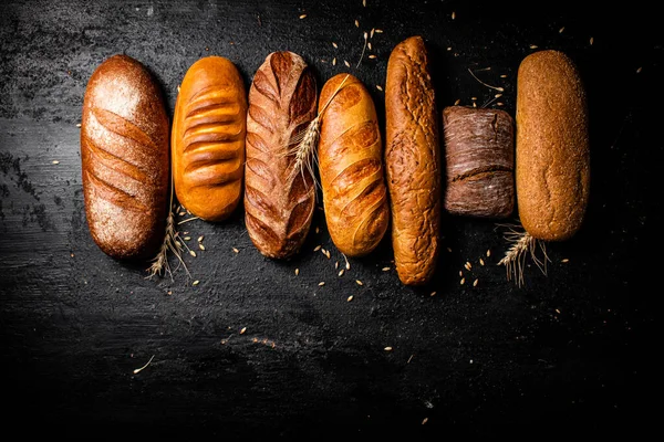 香り高い新鮮なパンの様々な 黒を背景に 高品質の写真 — ストック写真