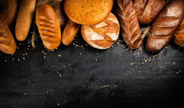Verschiedene Arten Von Frischem Brot Auf Dem Tisch Auf Schwarzem — Stockfoto