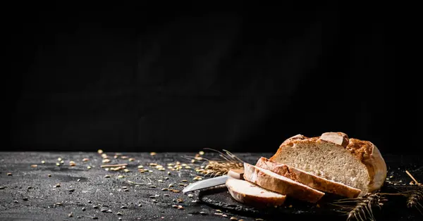 石板の上で穀物と小麦のパンをスライス 黒を背景に 高品質の写真 — ストック写真