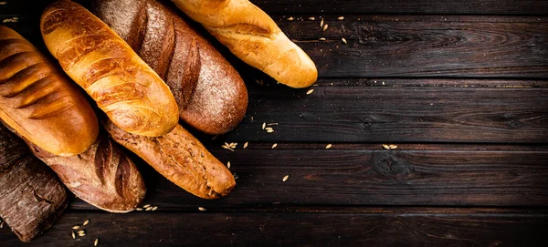 Verschiedene Arten Von Frischem Knusprigem Brot Auf Einem Hölzernen Hintergrund lizenzfreie Stockfotos