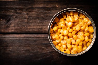 Açık konserve mısır konservesi. Ahşap bir arka planda. Yüksek kalite fotoğraf