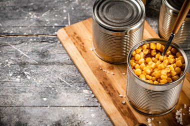 Kesme tahtasında konserve mısır konservesi. Gri bir arka planda. Yüksek kalite fotoğraf